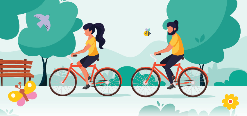 An active senior woman and man riding their bikes along a winding park path